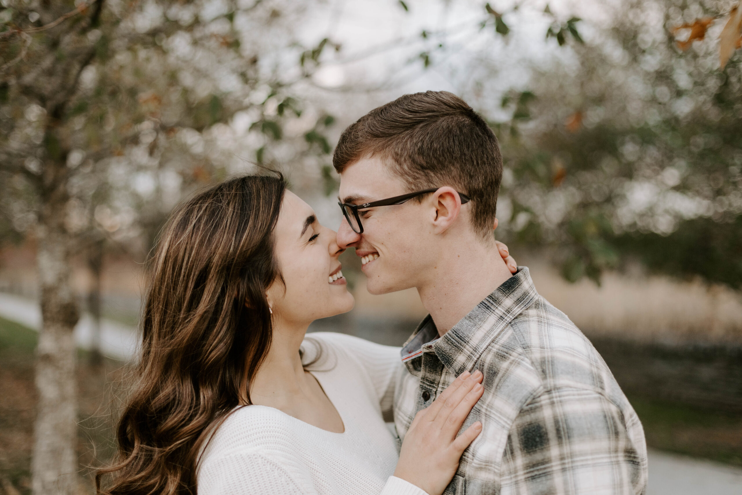 bride and groom smiling at each other and touching noses at engagement session