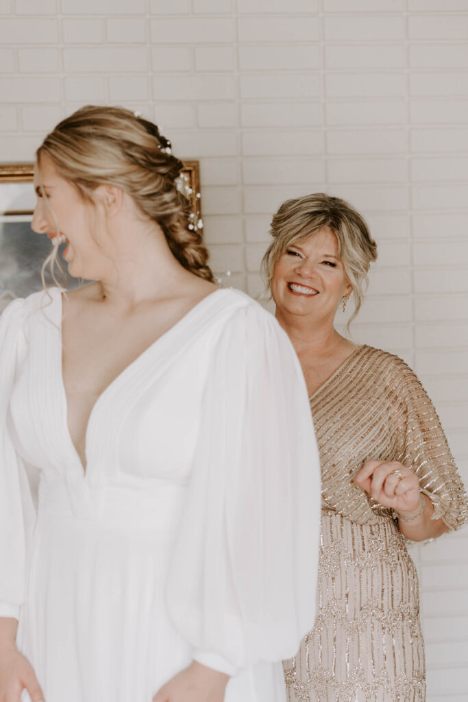 Mother of bride smiles at her daughter in beautiful getting ready photos